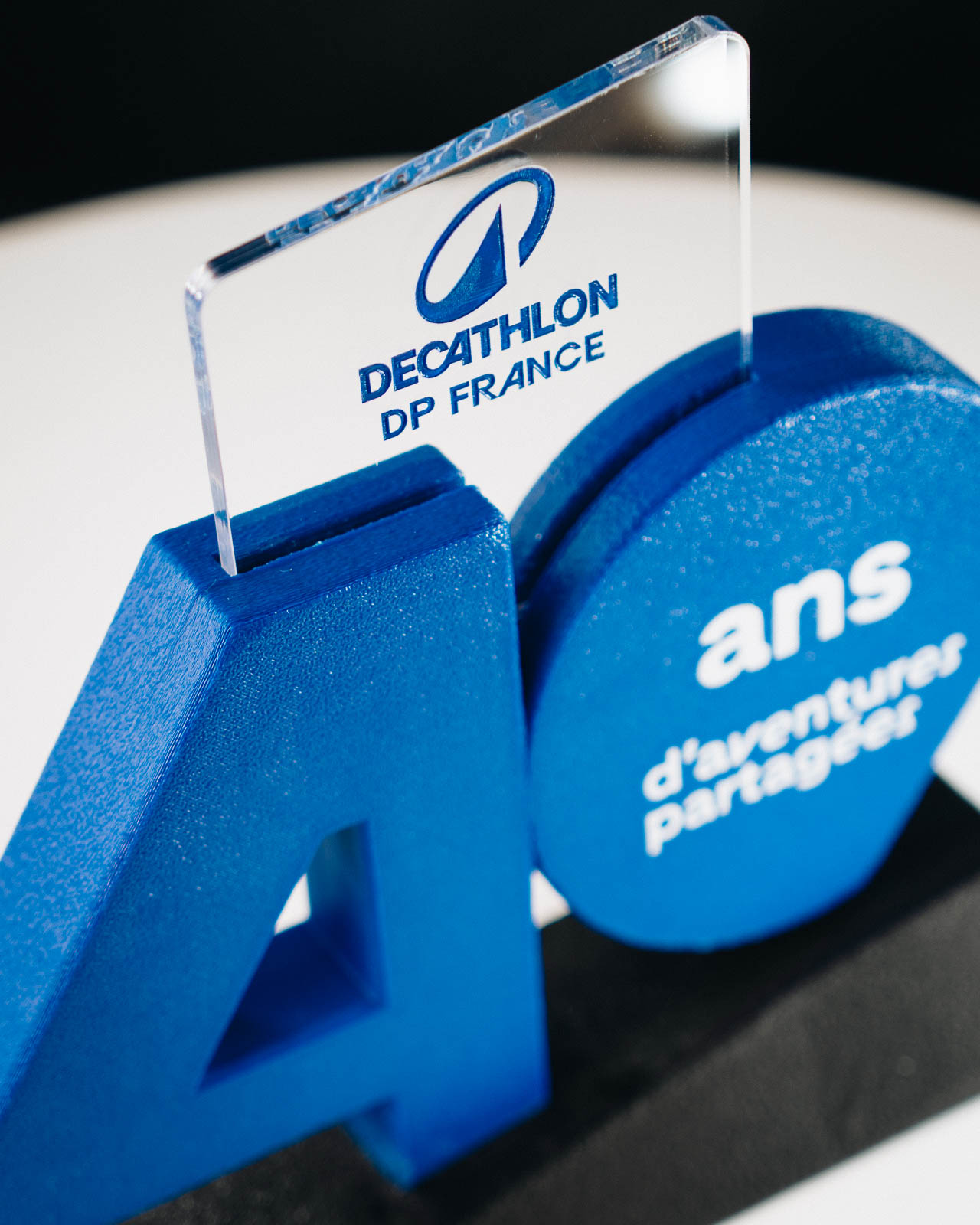 Trophée sur-mesure des 40 ans de Decathlon DP France imprimé en 3D, bleu de la marque et plexiglass gravé