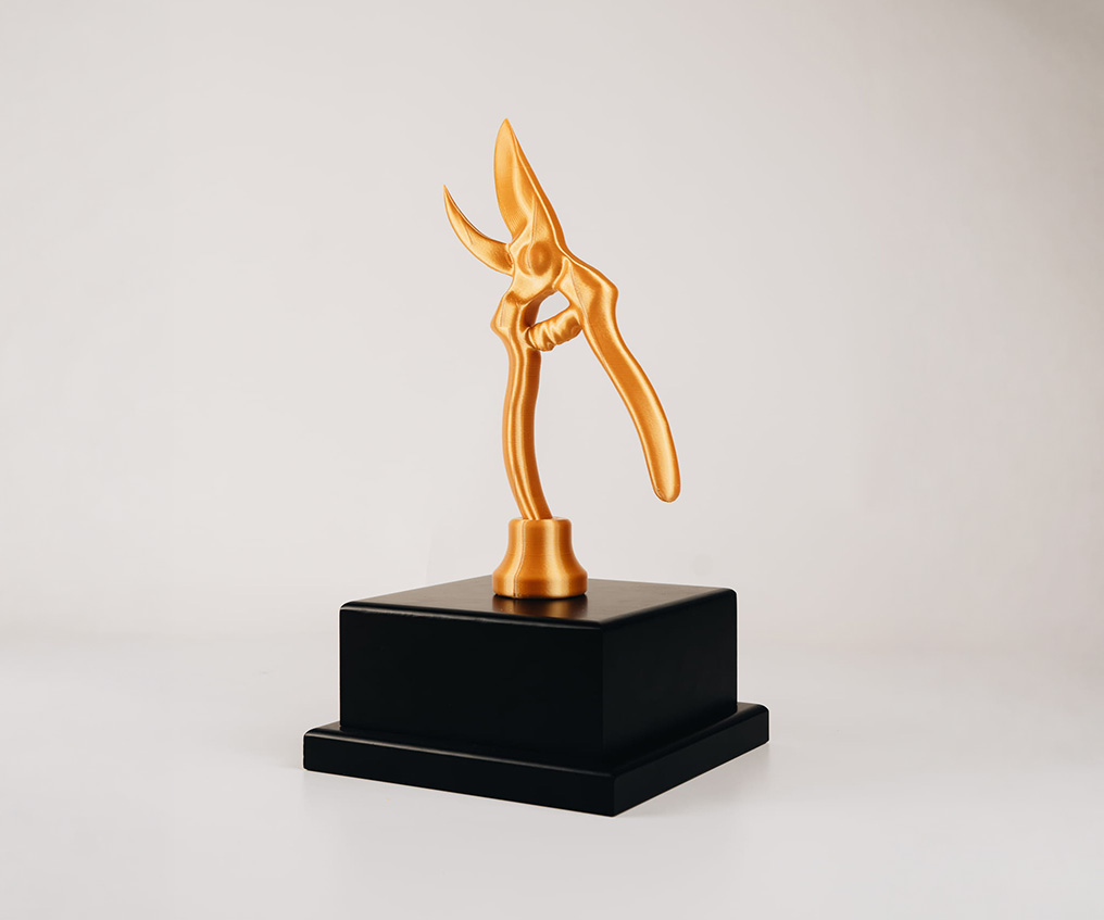Trophée sécateur doré sur socle noir imprimé en 3D